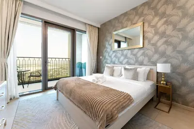 a bedroom with a large bed with a large window at Downtown Views II 2 Bedroom with City Skyline and Sea Views in Dubai