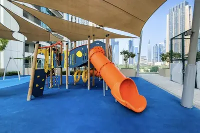 a playground with an orange slide in a building at Downtown Views II 2 Bedroom with City Skyline and Sea Views in Dubai