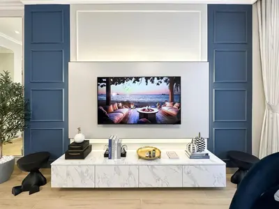 a living room with a tv on a wall at Elegant 2BR Plus Guest Room Stay with Designer Interior in Dubai