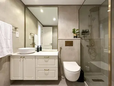 a bathroom with a toilet and a sink and a shower at Elegant 2BR Plus Guest Room Stay with Designer Interior in Dubai