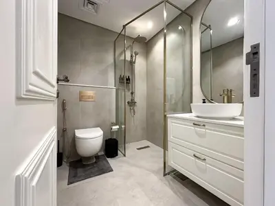 a bathroom with a sink and a toilet and a mirror at Elegant 2BR Plus Guest Room Stay with Designer Interior in Dubai