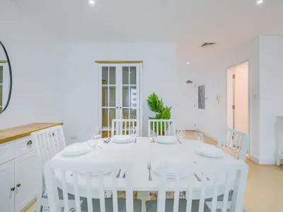 a white dining room with a white table and chairs at TRPS - Marina Heights Tower, Dubai Marina - 2BR Upgraded Apartment - with Stunning Marina Skyline in Dubai