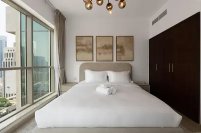 a bedroom with a white bed with a large window at 2 Bedroom Apartment BLVD Central 1 with Boulevard Views in Dubai