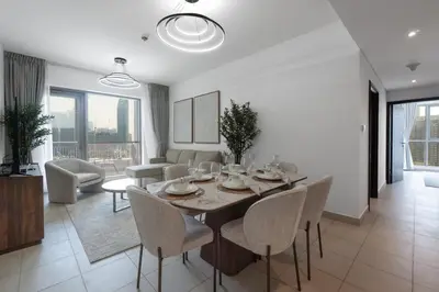 a dining room with a table and chairs in a living room at 2 Bedroom Apartment BLVD Central 1 with Boulevard Views in Dubai