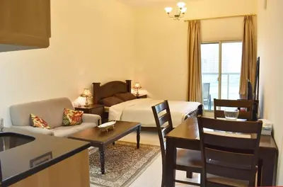 a living room with a couch and a bed and a table at Relaxing and luxurious studio-Dubai in Dubai