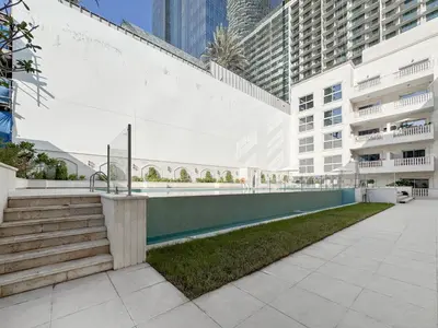 a walkway in a city with tall buildings at Stylish JVC 2BR Stay with Guest Room Rose Gold Accents in Dubai