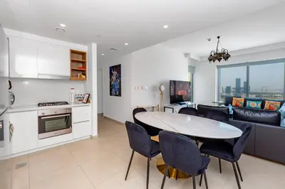 a kitchen and a living room with a table and chairs at Downtown Views II 2 Bedroom Apartment Next to Dubai Mall in Dubai
