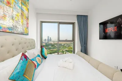 a bedroom with a white bed with a large window at Downtown Views II 2 Bedroom Apartment Next to Dubai Mall in Dubai