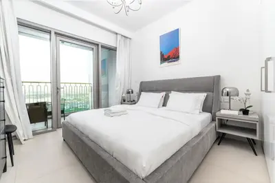 a white bedroom with a large bed and a large window at Stunning Corner 2 Bedroom in Downtown Views II in Dubai