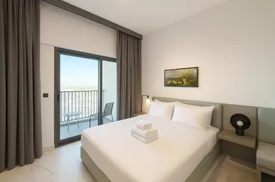 a hotel room with a bed and a balcony at Stylish Studio in Meydan 10mins away Burj Khalifa in Dubai