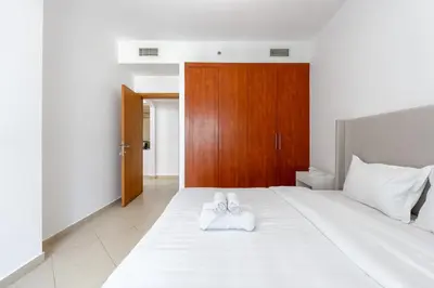 a bedroom with a bed with two white towels on it at Apartment Close to Metro in Dubai Marina in Dubai