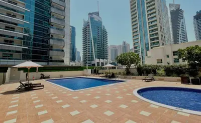 a swimming pool in a city with tall buildings at Apartment Close to Metro in Dubai Marina in Dubai