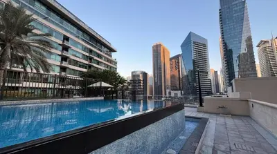 a swimming pool with a city skyline in the background at Luxury 1BR Dubai Marina Apartment Walk to JBR Beach & Marina Yacht Club in Dubai