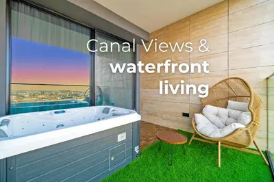 a bathroom with a tub and a chair and a window at SettlerHomes - Private Jacuzzi Oasis on the High-Floor in Dubai