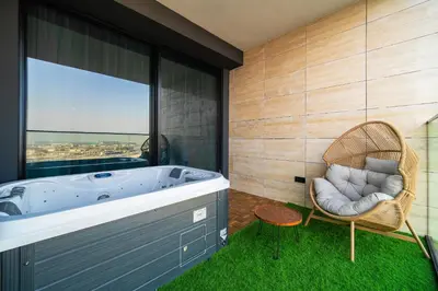 a bathroom with a jacuzzi tub and a chair at SettlerHomes - Private Jacuzzi Oasis on the High-Floor in Dubai