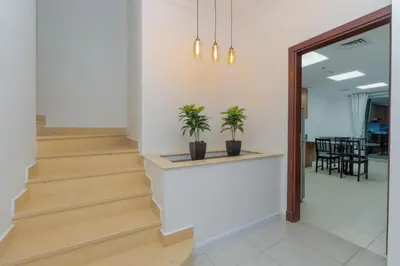 a hallway with stairs with two potted plants at Duplex Penthouse on 73rd Floor in Dubai Marina in Dubai
