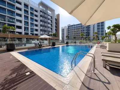 a large blue swimming pool in a building at Stylish 1BR near Business Bay, Meydan Racecourse & Crystal Lagoon in Dubai