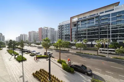 a city street with cars parked in front of a building at Stylish 1BR near Business Bay, Meydan Racecourse & Crystal Lagoon in Dubai