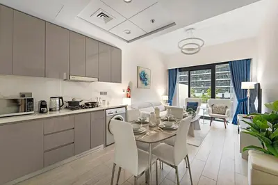 a kitchen and dining room with a table and chairs at Stylish 1BR near Business Bay, Meydan Racecourse & Crystal Lagoon in Dubai