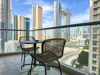 two chairs and a table on a balcony with a city skyline at The Lofts, Burj Khalifa View in Dubai