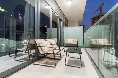 a balcony with chairs and a table on a building at FIRST CLASS 1BR Contemporary Comfort in Dubai
