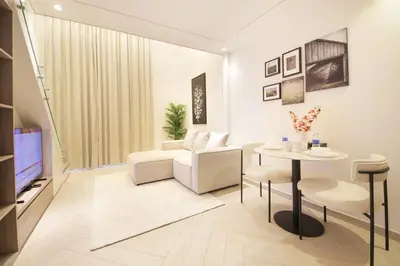 a living room with a couch and a table at Modern Loft Studio JVC ,Stylish & Fully Furnished in Dubai