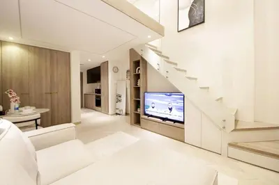 a living room with a staircase and a television at Modern Loft Studio JVC ,Stylish & Fully Furnished in Dubai