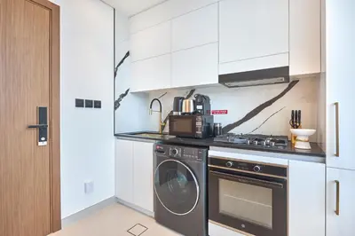 a kitchen with a washer and a washing machine at Charming Studio with Scenic Canal Views in Dubai