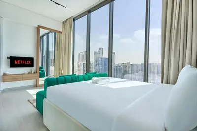 a bedroom with a large bed and a large window at Charming Studio with Scenic Canal Views in Dubai