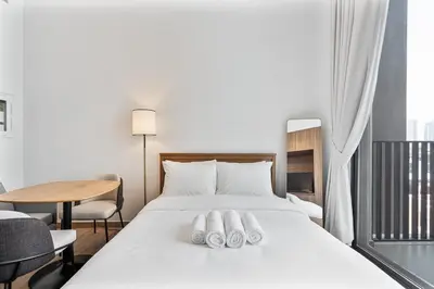 a bedroom with a bed with two towels on it at Bright Studio in JVC with Pool and Gym Access in Dubai