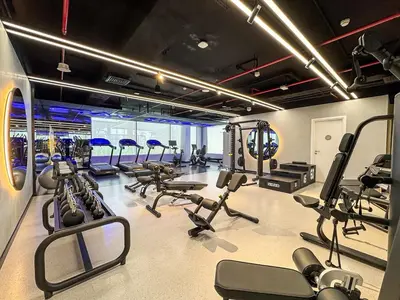 a gym with a bunch of treadmills and machines at Bright Studio in JVC with Pool and Gym Access in Dubai