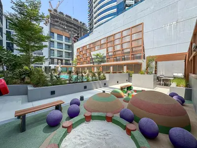 a courtyard with purple chairs and benches in a city at Bright Studio in JVC with Pool and Gym Access in Dubai