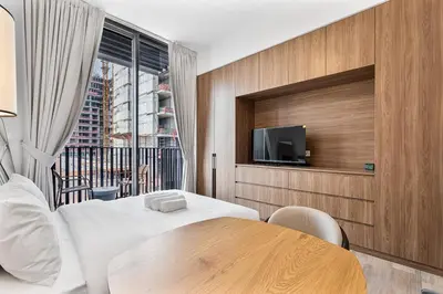 a hotel room with a table and a tv at Bright Studio in JVC with Pool and Gym Access in Dubai