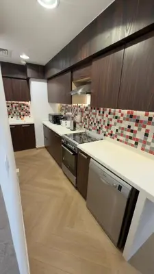 a kitchen with wooden cabinets and a counter top at Highend Azure 1BR Sea View and Private Beach with Pool Access in Dubai