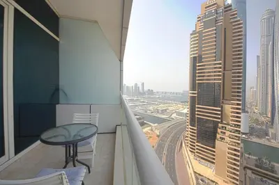 a balcony with a table and a view of a city at Silk Valley - Cozy Studio steps away from the Beach and Marina in Dubai
