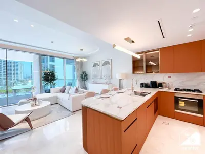 an open kitchen and living room with a couch at Seafront Serenity Palm Escape with Pool Access in Dubai