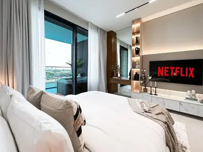 a master bedroom with a bed and a television at Dubai Studio with Balcony, Canal Views Pool Access in Dubai