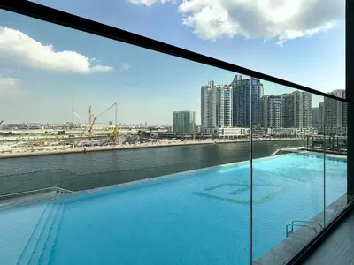 a view of a large swimming pool from a building at Dubai Studio with Balcony, Canal Views Pool Access in Dubai
