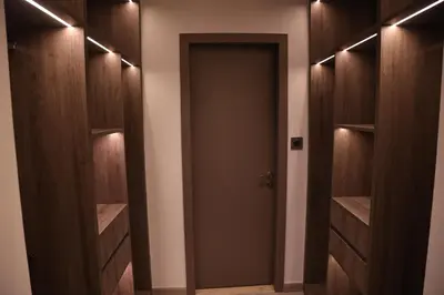 a walk in closet with wooden cabinets and a door at Highend 2BR Sea and Beach View in Dubai