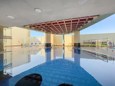 an empty swimming pool with a tennis court at FIRST CLASS 2BR Cozy City Retreat in Dubai