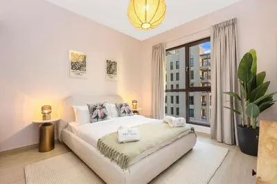 a bedroom with a large bed and a large window at FIRST CLASS 1BR Classic Luxe Getaway in Dubai