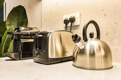 a kitchen sink with a tea kettle on a counter at FIRST CLASS 1BR Classic Luxe Getaway in Dubai