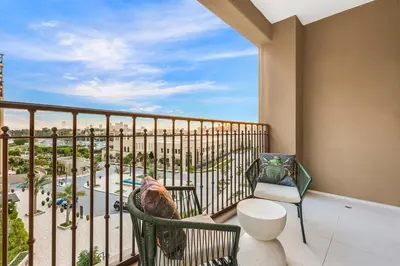 a balcony with a chair and a view of a resort at FIRST CLASS 1BR Classic Luxe Getaway in Dubai