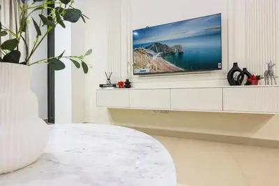 a living room with a flat screen tv on a wall at Stylish 2BR Downtown Dubai with Skyline & Burj Khalifa Views in Dubai