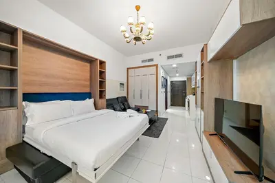 a bedroom with a large bed and a television at FIRST CLASS Studio Elegant Escape, Cozy Luxe in Dubai