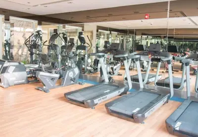 a gym with a bunch of cardio equipment at FIRST CLASS Studio Elegant Escape, Cozy Luxe in Dubai