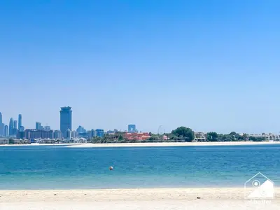 a view of a beach with a city in the background at Luxury Beachfront 1BR on Palm Jumeirah & Balcony in Dubai