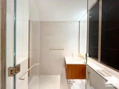 a bathroom with a sink and a glass shower at Luxury Beachfront 1BR on Palm Jumeirah & Balcony in Dubai