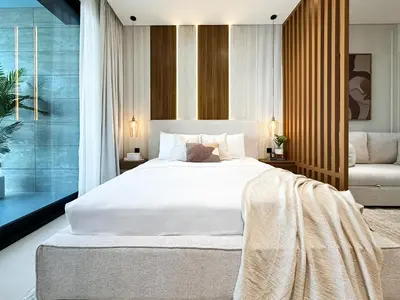 a bedroom with a large white bed and a chair at Peaceful Studio Stay Canal Views Poolside Comfort in Dubai