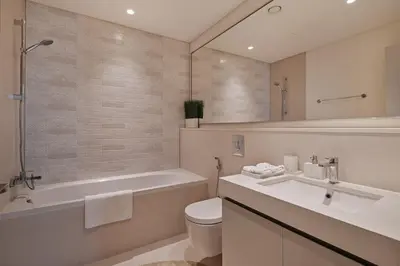 a bathroom with a tub and a toilet and a sink at 4BR Beachfront Marina & Palm View in Dubai